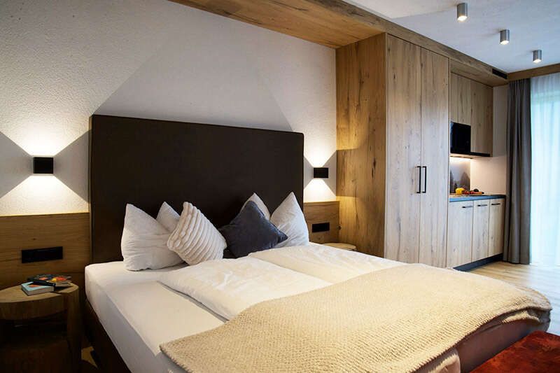 Double bed and kitchenette in Apartment A2 at the Versalerhof