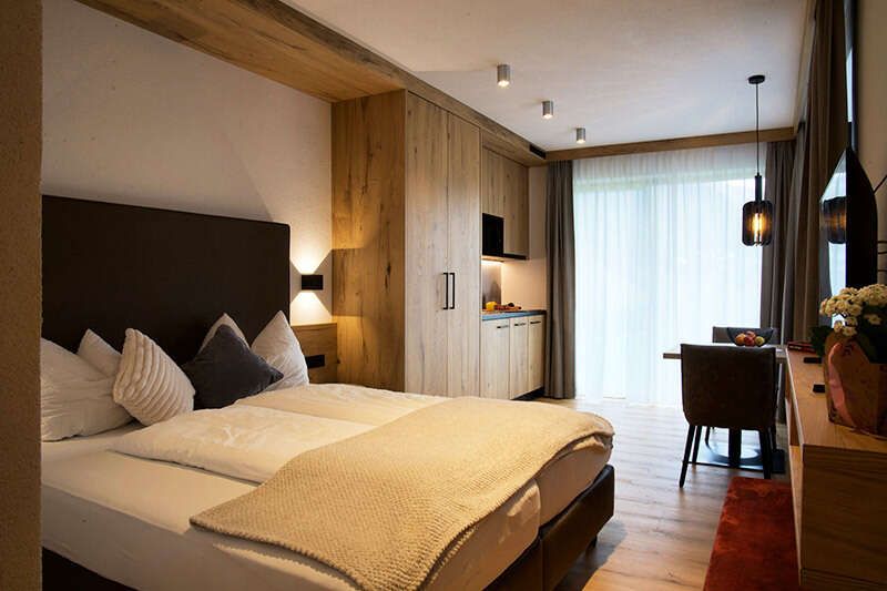 Room with a double bed and kitchen in Apartment A2